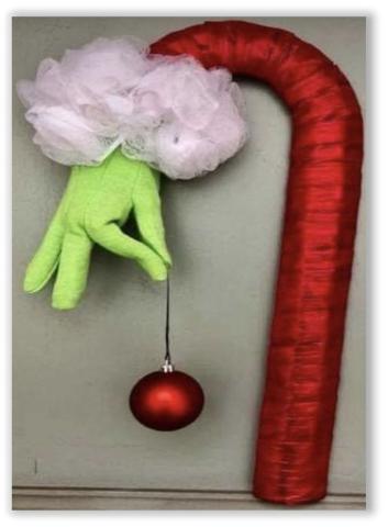 Candy cane wreath wrapped in red silk. Bright green glove on end holding a red ornament. 