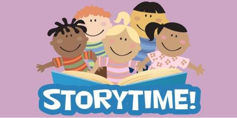 5 children sitting in front of a blue story book with the words storytime!