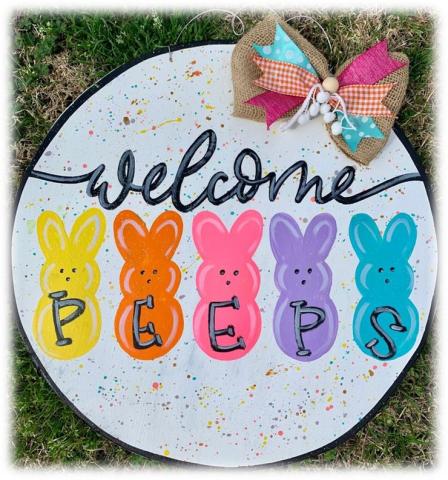 White circle sign that says welcome, with 5 peeps in different colors (yellow, orange, pink, purple, and blue) with PEEPS spelled out on their bodies. 