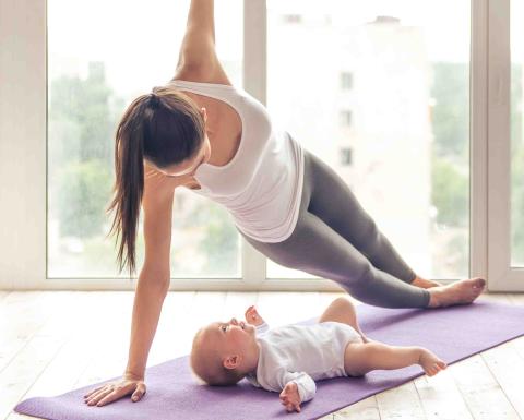 Mom and baby stretching on a purple mat.