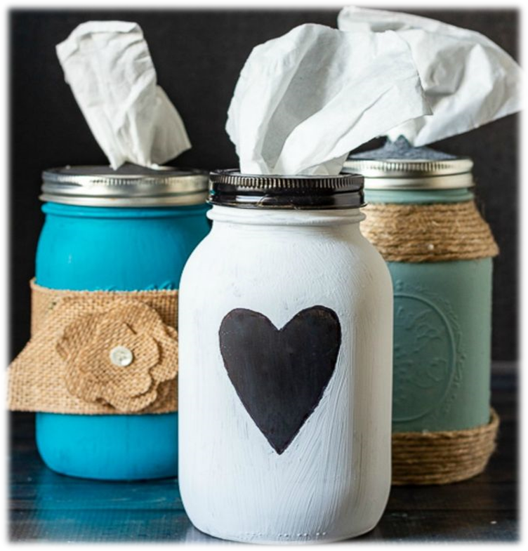 White, light blue and turquoise mason jars filled with tissues. White jar has a black heart, turquoise jar has a burlap flower and light blue jar has sisal rope. 