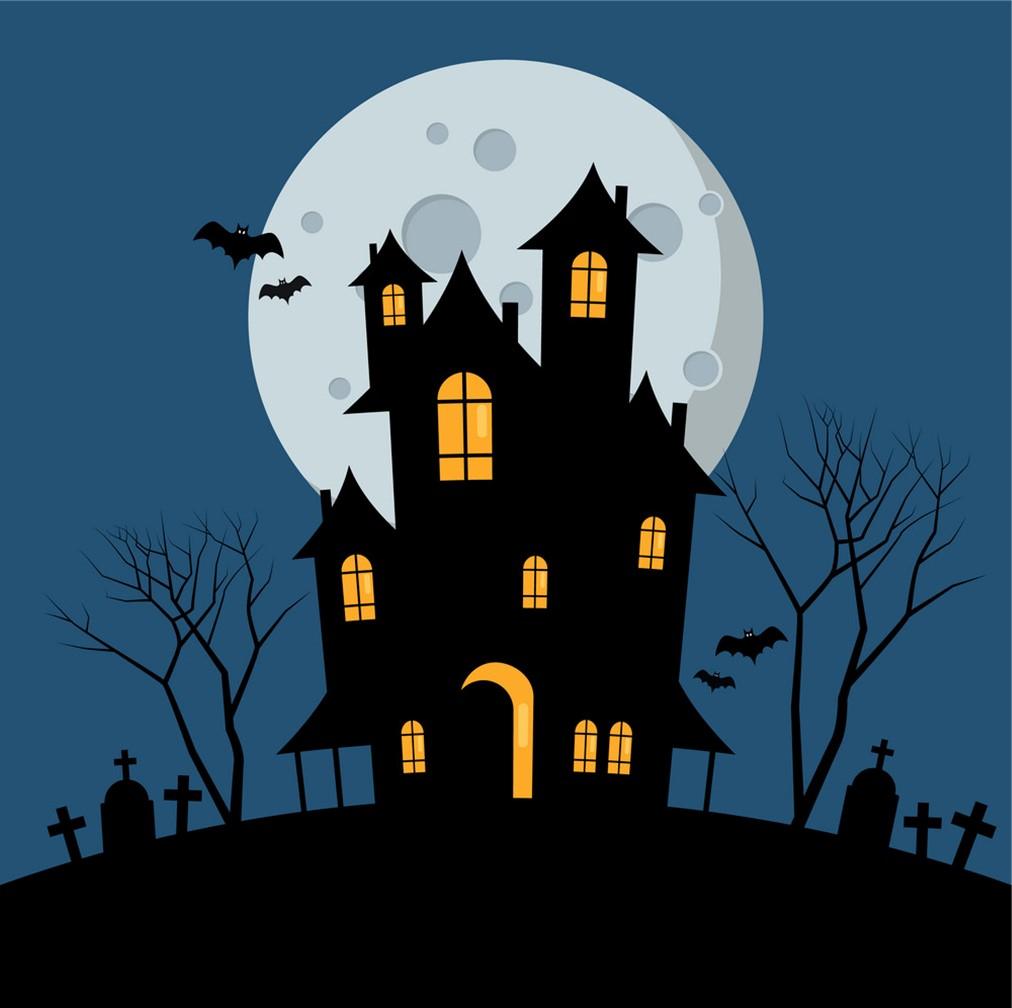 haunted house with yellow windows in front of full moon in a barren graveyard